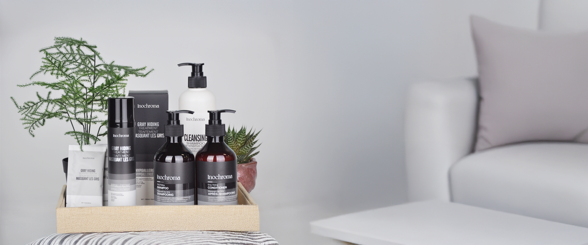 Bathroom products including bottles and boxes on a wooden tray with a neutral background.