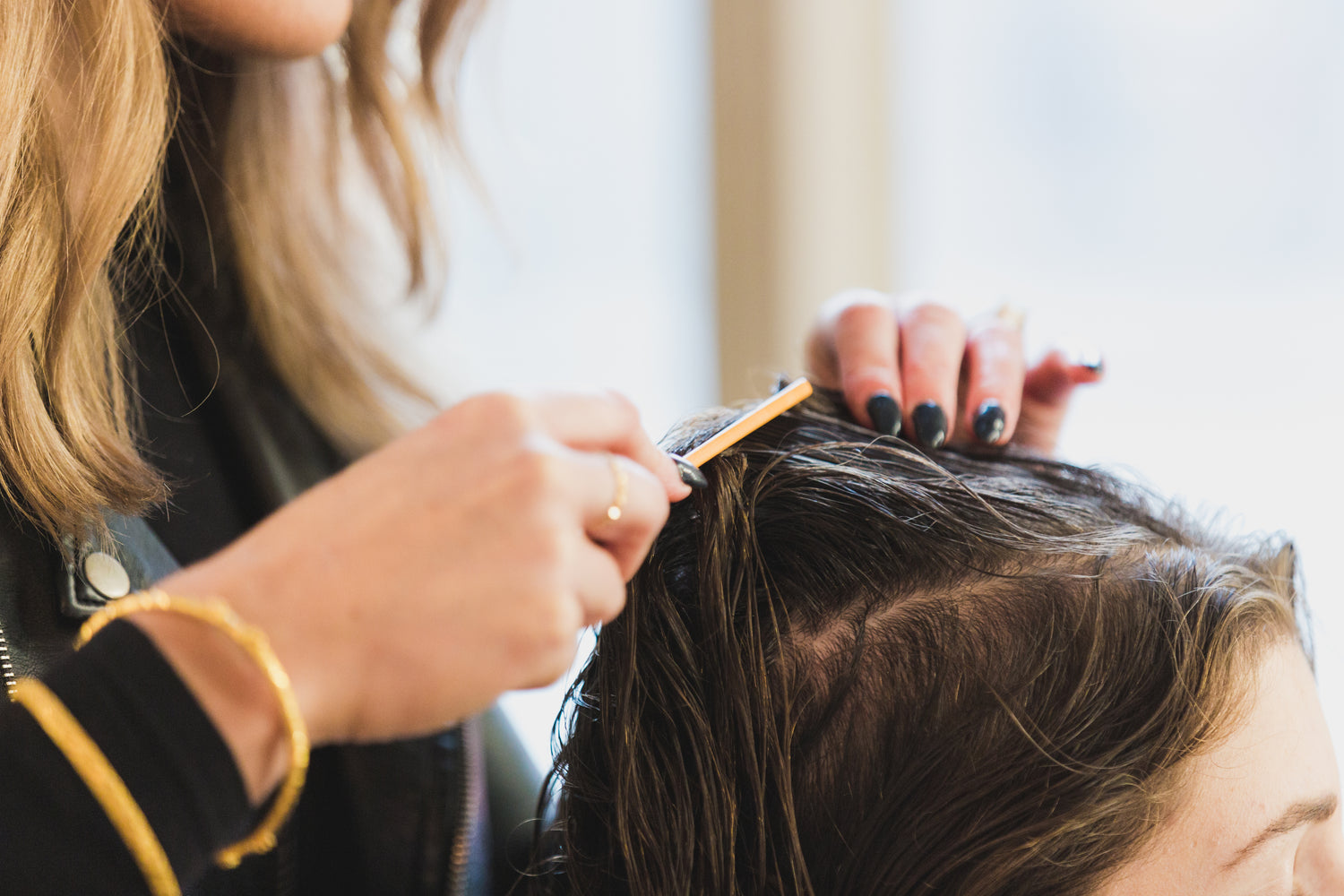 Stylist applying Color Safe Gray Hiding Shampoo to hair roots